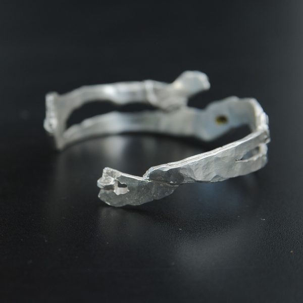 Détail du bracelet “Tempête” en argent et or, serti d’une tourmaline verte. Bijou artisanal Fusyom, fait main à Oléron.